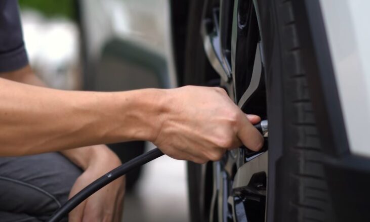 Man checking tire pressure on his car