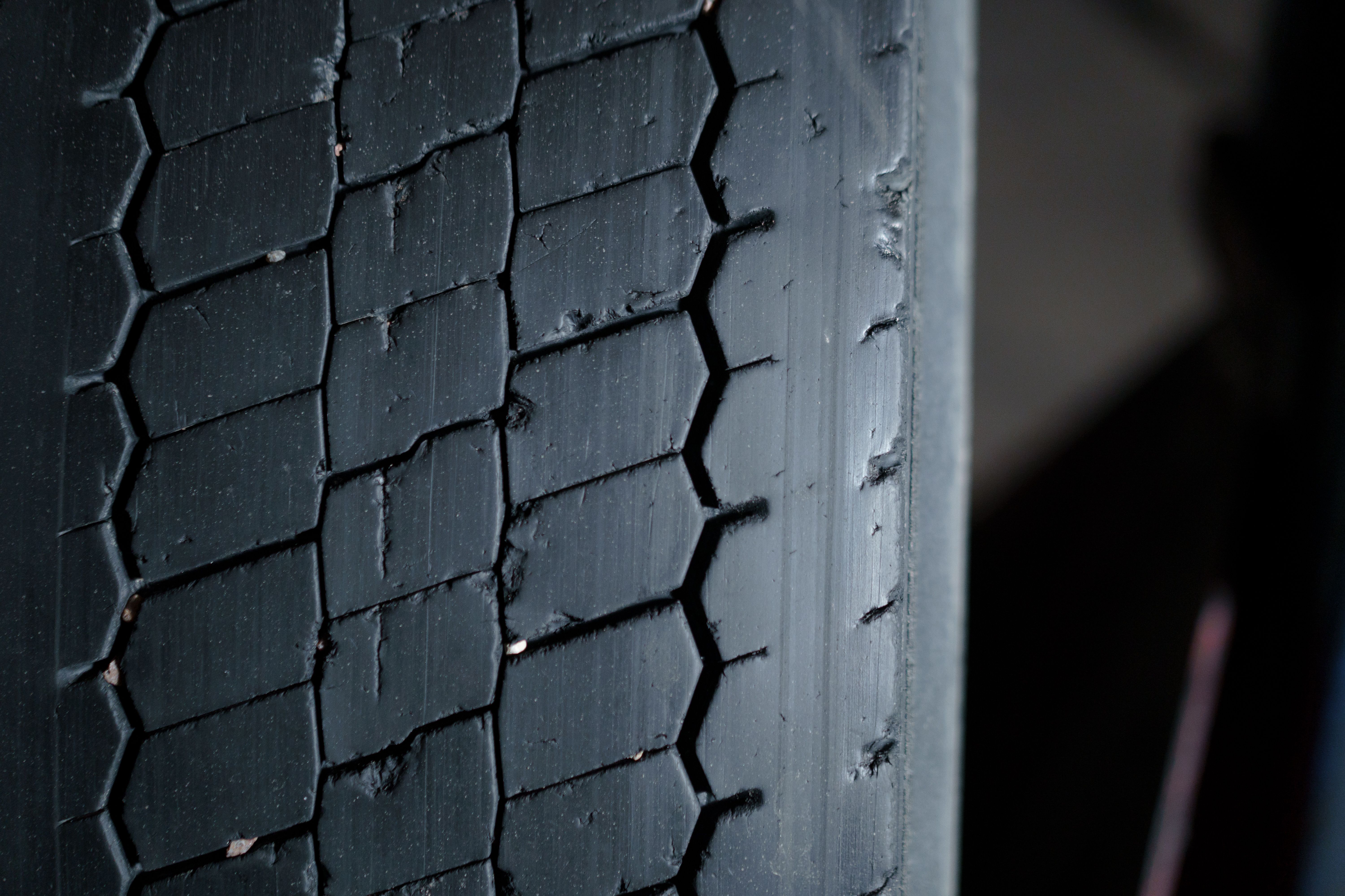 Detailed close-up of a worn truck tire tread showing dangerous wear patterns